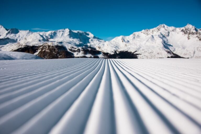 Pista appena battuta con sfondo montagne, traccia battipista